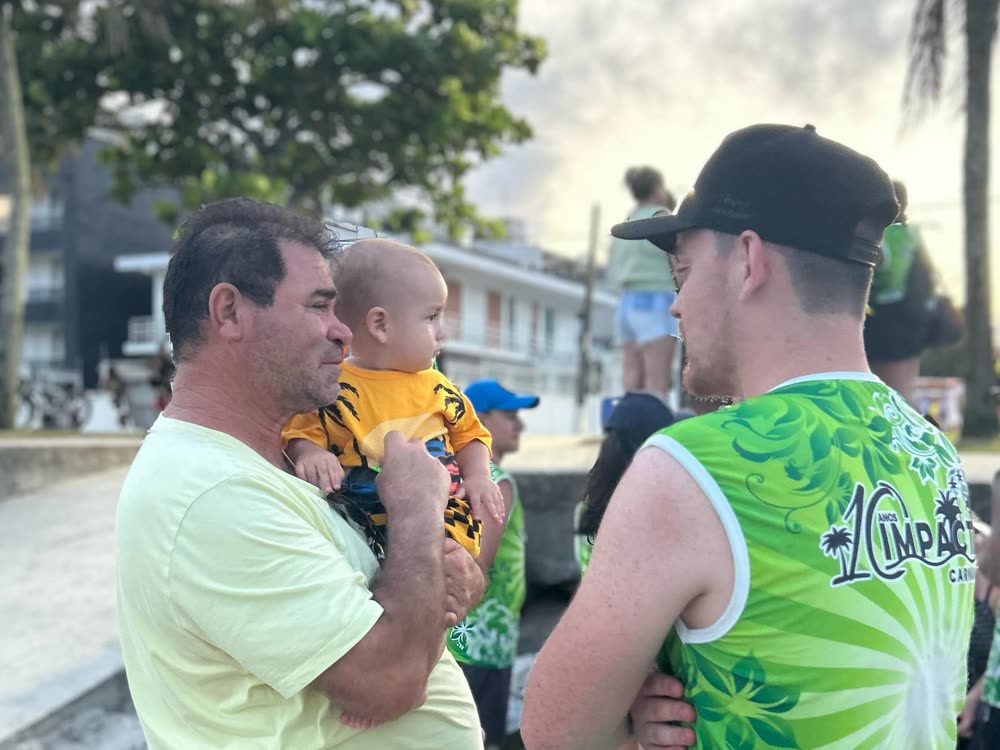 Voluntário conversando com um senhor que segura um bebê