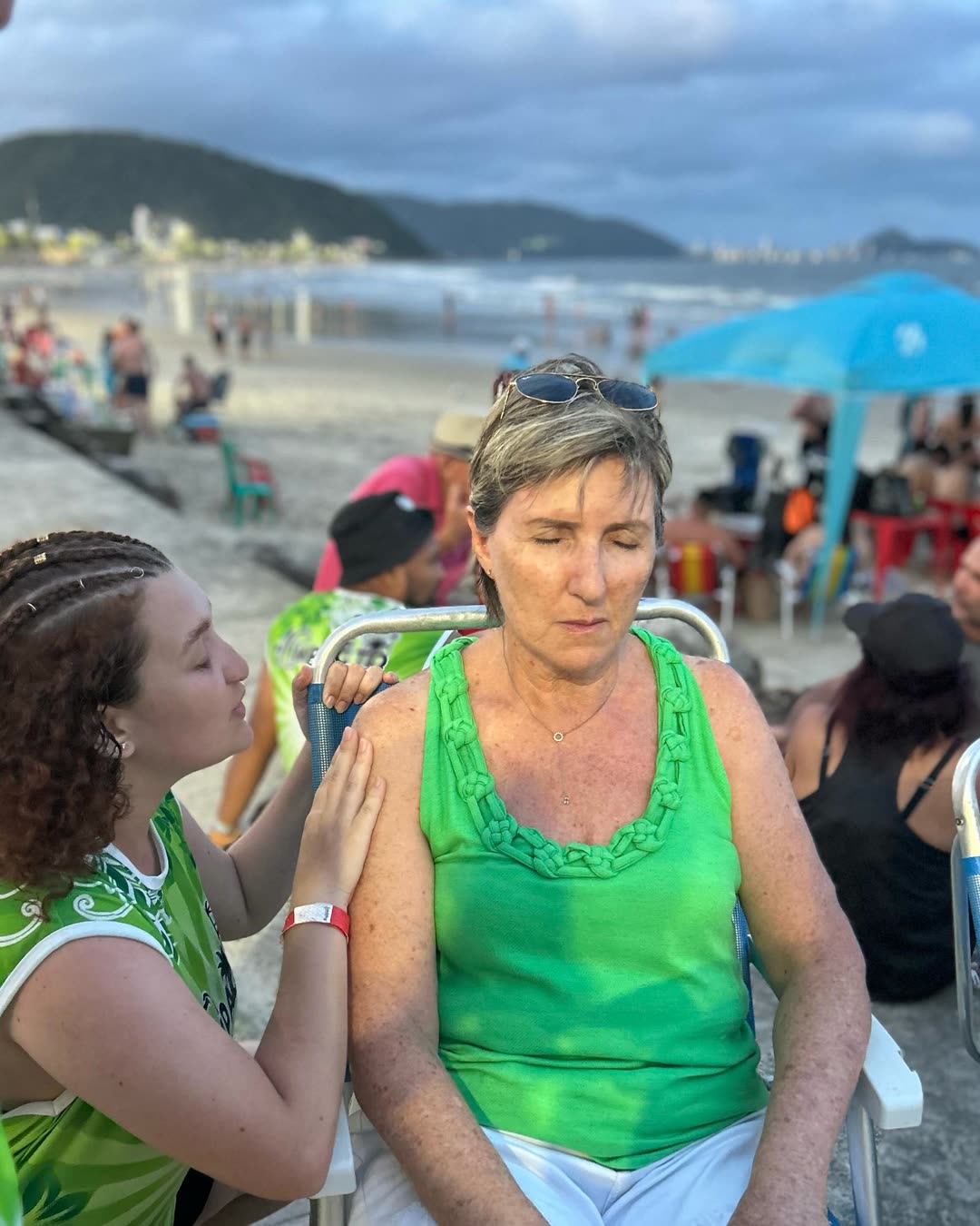 Voluntária do Impacto orando por uma senhora na praia